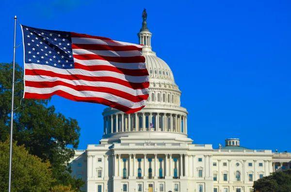 An American flag flying in front of the U.S. Capitol